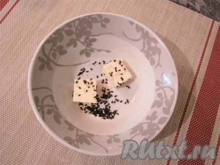 Обвалять каждый кубик сыра в смеси чёрного и белого кунжута. 