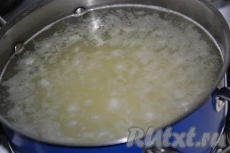 В кастрюлю влить 2 литра воды, довести до кипения на сильном огне, выложить картофель и рис, варить 15 минут с момента закипания на небольшом огне.