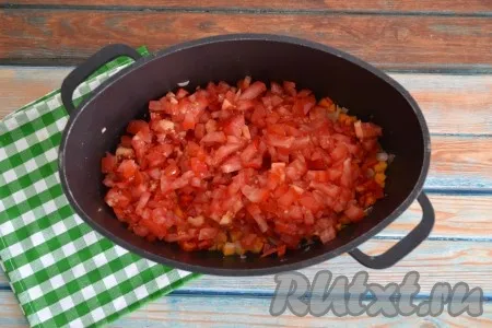 Сделать на коже каждого помидора крестовой надрез. Залить полностью помидоры кипятком на 1 минуту, затем слить воду и снять кожуру. Очищенные помидоры нарезать кубиками и выложит к луку, моркови и перцу.