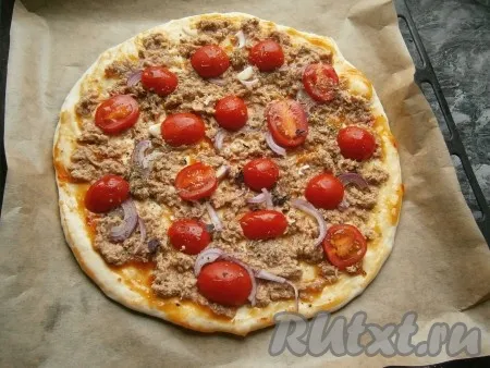 Помидоры черри разрезать на 2 части (если крупные - можно разрезать на 3-4 части) и разместить их на заготовке пиццы, сверху посыпать сушёным базиликом. 