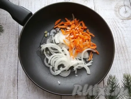 Нарезать луковицу на тонкие полукольца. Очищенную половину моркови нарезать соломкой. Выложить нарезанные морковку с луком в сковороду с разогретым растительным маслом.