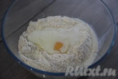 Теперь замесим тесто, для этого нужно просеять в миску муку, добавить 1 чайную ложку соли, сырое яйцо и влить кефир.