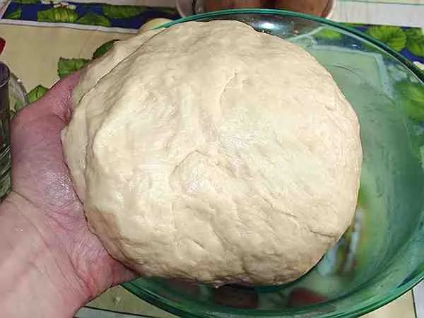постное тесто для картофельного пирога в руке 
