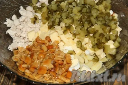 Добавить маринованные опята, сыр и огурцы в салат из куриной грудки, картошки, яиц и моркови. 