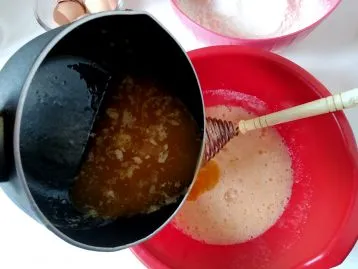 Затем добавить топленое масло и перемешать пару минут, чтобы сахар растворился.