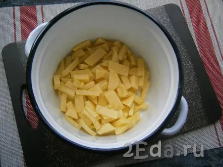 Очистить лук, картофель и морковь, удалить плодоножку с семенами из болгарского перца. Картошку нарезать на небольшие кусочки и поместить в кастрюлю.