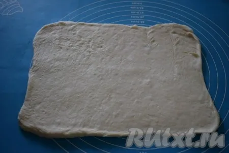 Слоёное дрожжевое тесто размораживаем. Для этой закуски нам потребуется 1 лист слоёного теста, слегка раскатываем его на припылённой мукой поверхности.
