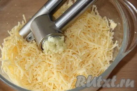 Сыр натереть на мелкой тёрке. Чеснок очистить и пропустить через пресс. Соединить сыр и чеснок.
