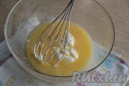 Перемешать яйца с сахаром с помощью венчика. Затем добавить сметану и снова перемешать.