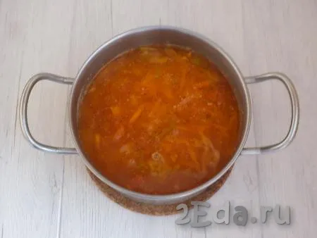 Когда картошка будет практически готова, добавьте в суп овощи, обжаренные с томатной пастой, дайте закипеть, убавьте огонь и варите щи 10 минут.