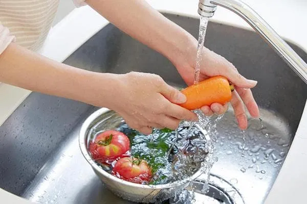 Мытье моркови под краном