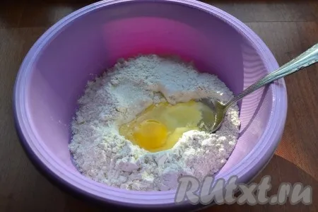 Для приготовления теста для блинов муку просеять в глубокую миску, добавить соль, сахар и сырое яйцо.