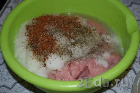 В миску с фаршем добавим соль, чёрный молотый перец, специи, измельчённый лук и тщательно перемешаем.