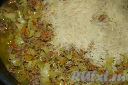 Рис промыть и добавить на сковороду к капусте с фаршем. Залить 100 мл воды. 