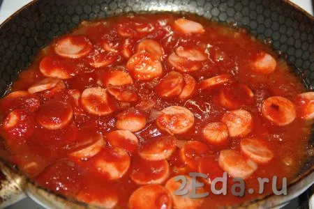 Перемешать сосиски с томатным соусом и потомить на небольшом огне 3-4 минуты. Добавить любые специи, перемешать.