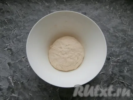 Замесить не липнущее, но мягкое тесто. Поместить тесто в миску, которую нужно сверху прикрыть плёнкой, и оставить в тёплом месте на 40 минут. 