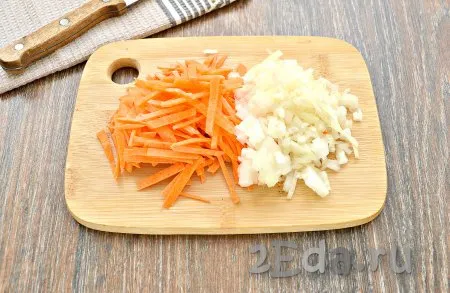 Очистить морковку с луком. Овощи ополоснуть. Морковку нарезать тонкими брусочками. Репчатый лук нарезать на небольшие кубики. В съёмную чашу мультиварки влить растительное масло, установить программу «Жарка», выложить морковку с луком и обжарить в течение 5 минут, не закрывая крышку мультиварки, периодически перемешивая овощи.