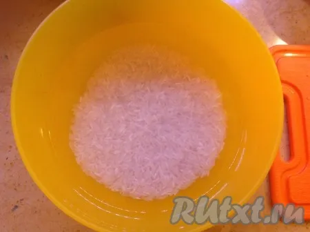 Замочить рис в воде и промыть 5-6 раз, сливая воду и не трогая рис руками. 