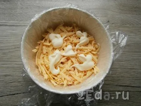 Следующим слоем выложить натертый сыр, хорошо смазать майонезом.