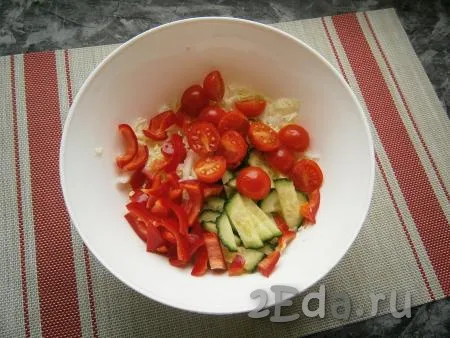 В салат из пекинской капусты и огурцов добавить болгарский перец, нарезанный соломкой, и помидоры черри, нарезанные на половинки (если используете обычные помидоры, тогда нарежьте их на дольки).
