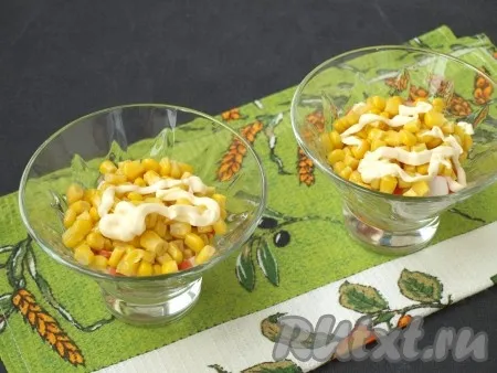 Далее выложить по 2 столовые ложки кукурузы в каждый салатник, смазать майонезом. 