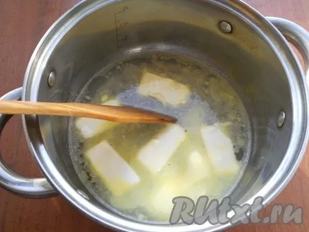 В кастрюлю влить воду, довести до кипения, добавить маргарин, нарезанный кусочками. Растопить маргарин полностью в воде. 
