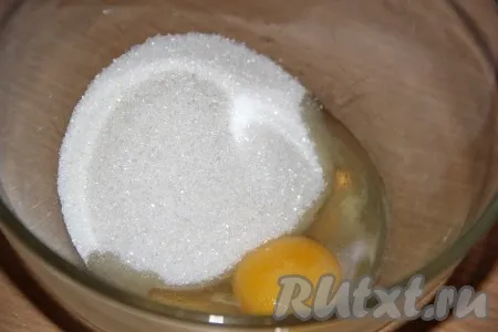 Насыпать в миску сахар, добавить яйцо. 
