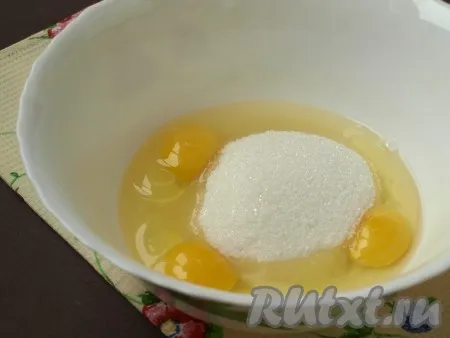 В отдельную миску разбить яйца, добавить сахар. 