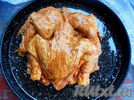 По истечении времени курицу, замаринованную в горчице, выложите спинкой вверх на противень, смазанный растительным маслом.