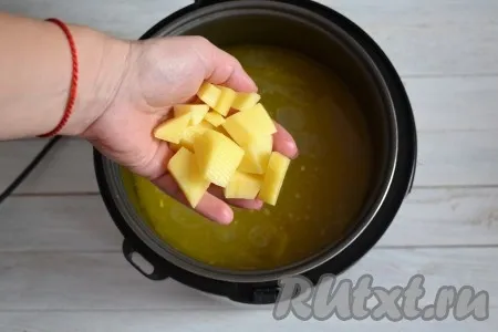 Очистить картофель и нарезать небольшими кубиками. Выложить его в бульон к перловке. Варить на функции 