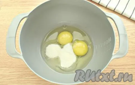 В миску разбиваем куриные яйца, добавляем к ним сахар, всыпаем соль.