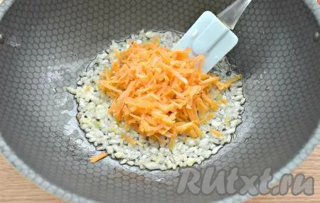 Затем выкладываем к луку натёртую морковку, обжариваем овощи минут 5-6, иногда перемешивая.
