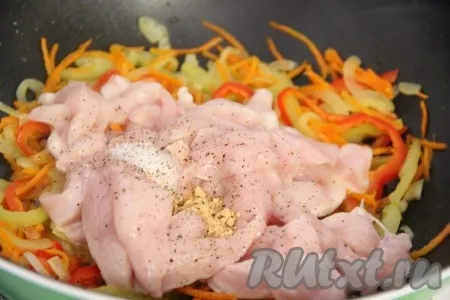 Добавить кусочки куриного филе в сковороду к овощам, затем всыпать соль, перец, имбирь.