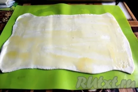 Смазать каждый лист слоёного теста растопленным сливочным маслом.