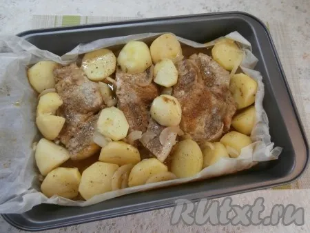 Отправить свиную корейку с картошкой в разогретую до 180 градусов духовку на 1 час. Затем верхнюю часть пергамента убрать (можно просто отрезать). Отправить противень снова в духовку ещё на 10-15 минут, чтобы картошка с мясом немного зарумянились.