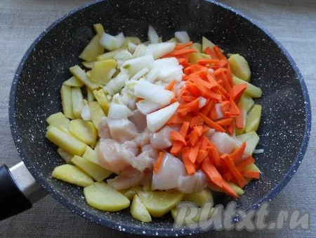 Разогреть растительное масло в сковороде, добавить туда нарезанный соломкой или кубиками картофель. Обжарить картошку на среднем огне, периодически помешивая, до небольшой румяной корочки (минут 5-7). Далее добавить к картофелю курицу, лук и морковь. Перемешать и обжаривать все вместе еще 7-10 минут на небольшом огне, периодически перемешивая. Картофель в итоге должен быть почти готов.