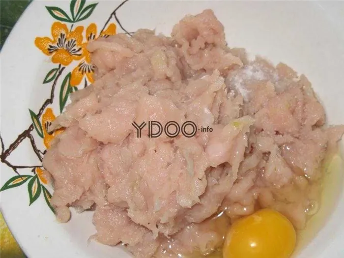 куриный фарш из филе с яйцом и солью в тарелке на столе