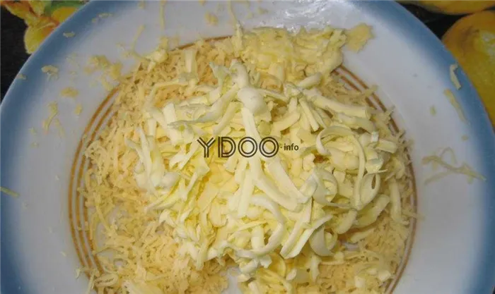 твердый сыр и сливочное масло, натертые на крупной терке, лежат на тарелке