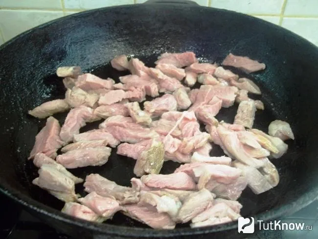 Мясо нарезано ломтиками и жарится на сковороде