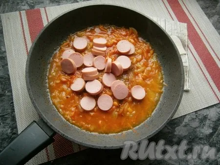 Выложить сосиски в сковороду с томатным соусом. 