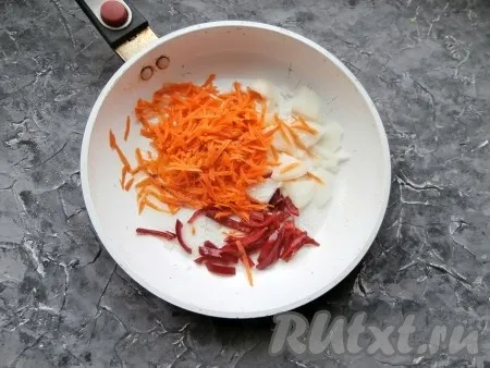 Морковку натереть на крупной тёрке, оставшуюся половину луковицы нарезать произвольно, болгарский перец нарезать соломкой, затем выложить овощи в сковороду, влить растительное масло. 