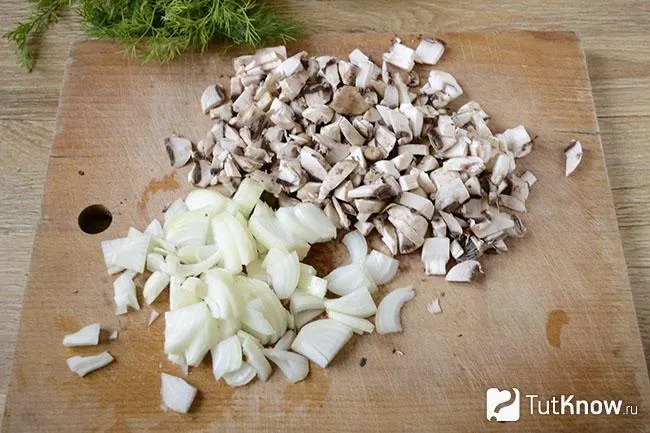 Нарезанные грибы и лук на кухонной доске