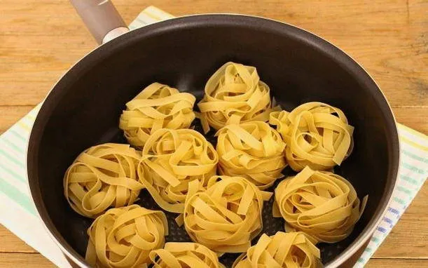 Гнезда из макарон с фаршем со сливками на сковороде