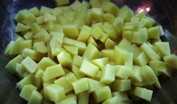 Нарезанный маленькими кубиками сырой картофель