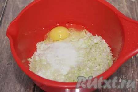 Капусту с луком всыпать в миску и хорошо помять руками. Затем к смеси капусты и лука влить кефир и добавить яйцо.
