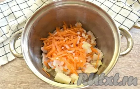 К обжаренному куриному мясу выкладываем натёртую морковь и нарезанный на небольшие кусочки лук, перемешиваем и обжариваем, не забывая помешивать, минуты 3-4.