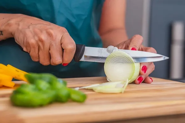 closeup of woman using a knife and cutting onion closeup cutting onion and vegetables - Рыбные котлеты