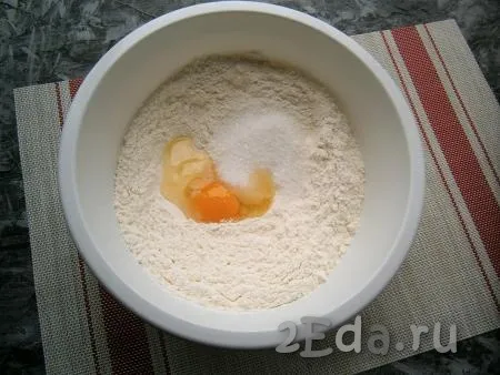 В муку всыпать соль, сахар, добавить яйцо.