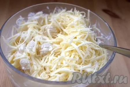Сыр натереть на крупной тёрке. Небольшую часть сыра отложить в сторонку, а оставшийся натёртый сыр добавить в миску к смеси макарон и творога. 