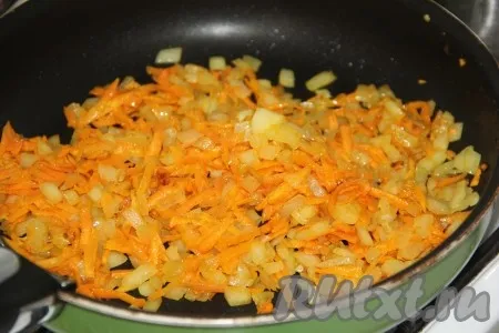 К обжаренному луку выложить натёртую морковь и обжарить на среднем огне, помешивая, в течение 5 минут. 